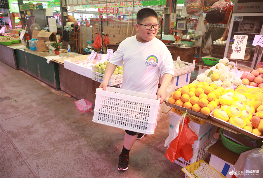 暑假当起小当家 青岛一男孩帮着父母照看水果摊